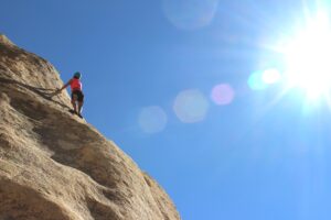 a woman rock climbing to symbolise thinking ahead as one of the job seeking tips