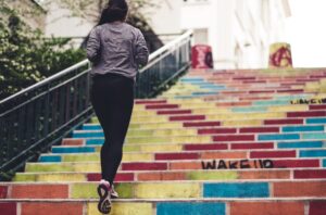 a woman running up stairs to represent being active as a tip for how to get put on the partner track