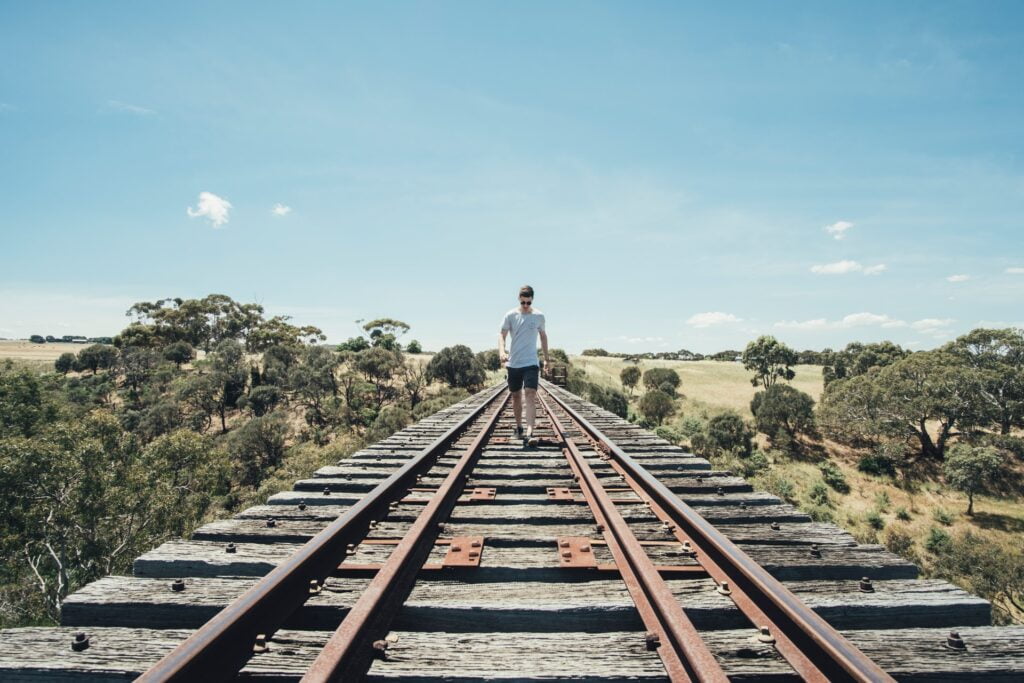 a man walking on train tracks to symbolise how to get put on the partner track