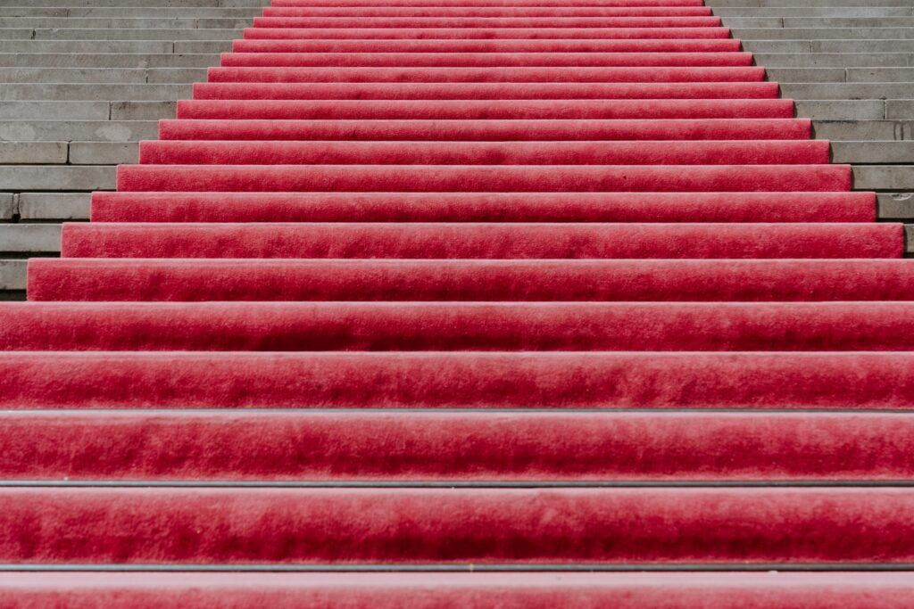 a red carpet leading upstairs to represent how to grow your profile among the partners