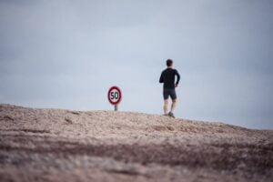 a man jogging by a 50 speed sign