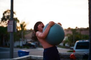 a boy squeezing a medicine ball